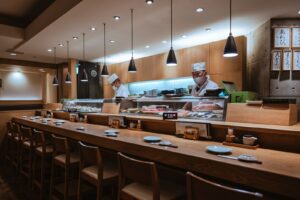 A sushi restaurant counter in Ginza, photographed by Ryunosuke Kikuno; general Tokyo dining context, not a recommended venue or evidence of dietary accommodation.